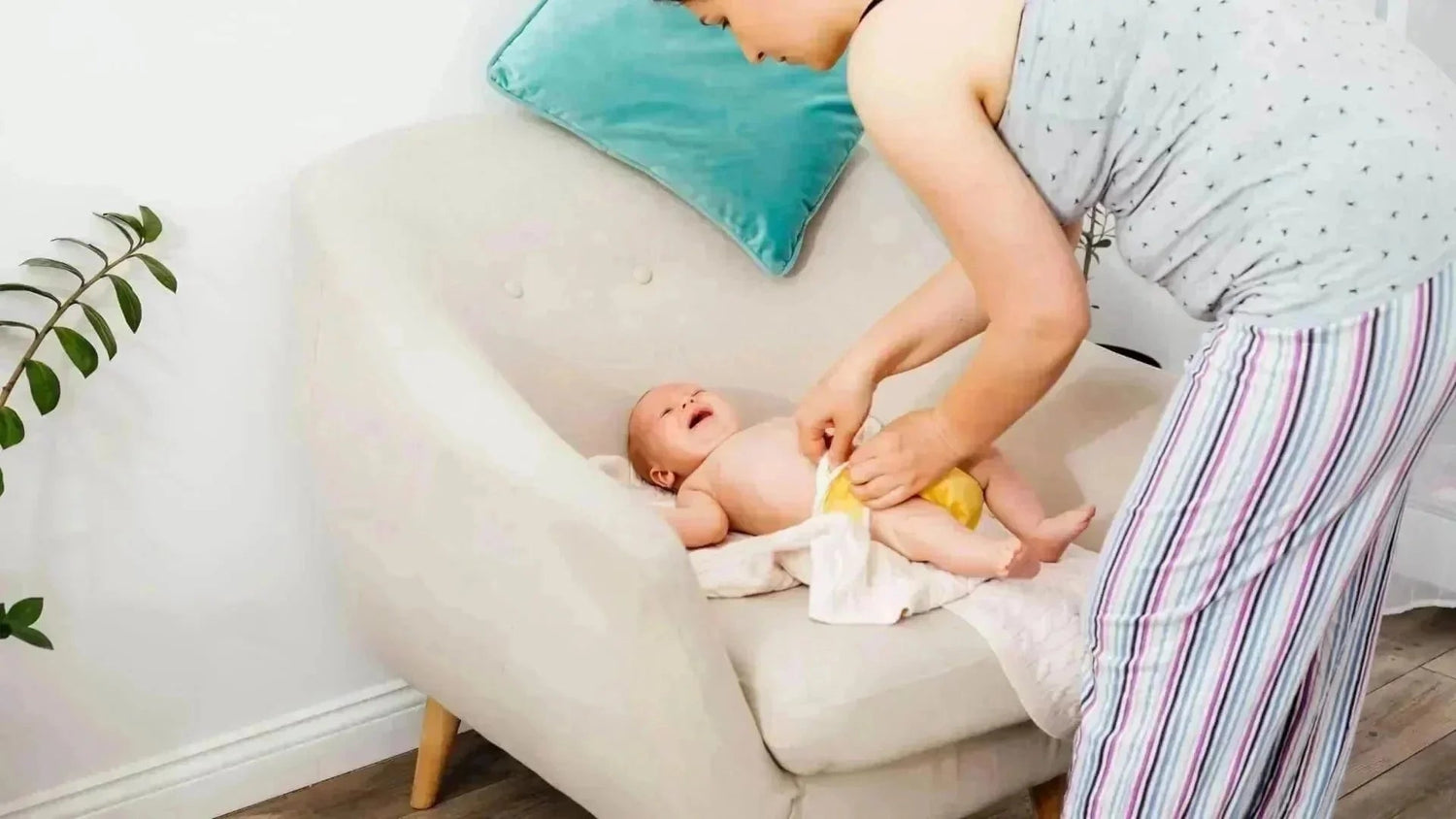 Maman change une couche lavable à son bébé